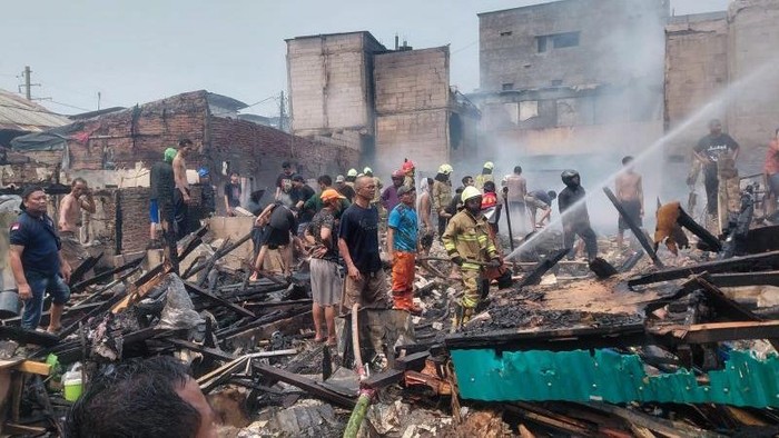 Petugas damkar memadamkan api yang membakar puluhan rumah di Kampung Muka, Ancol, Jakarta Utara, Minggu (27/9/2026) pagi.
