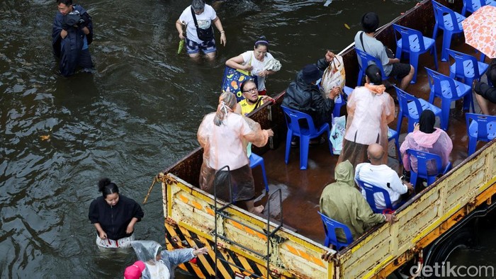 People board a truck equipped with plastic chairs to commute through a flooded area, in Bangkok, Thailand, September 28, 2026. REUTERS/Athit Perawongmetha     TPX IMAGES OF THE DAY