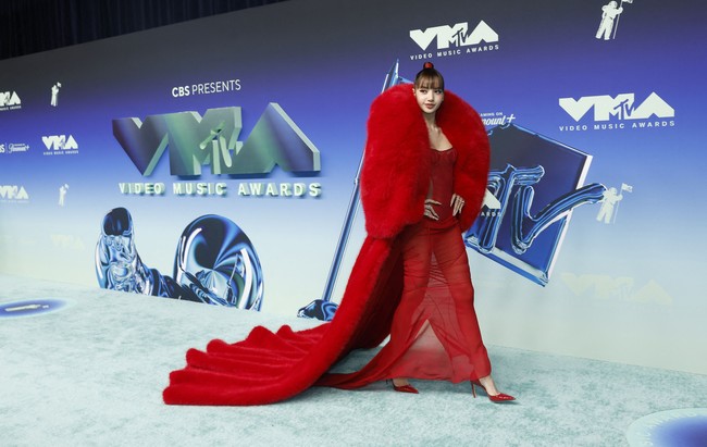 Queen of heart. Lisa Blackpink sukses mengalihkan atensi berkat gaun merah bustier yang seksi dari label Italia The Attico. Busana yang membungkus erat tubuhnya itu dilapis mantel tebal yang sarat statement keluaran Quine Li dari New York City. (Foto: REUTERS/Caroline Brehman)