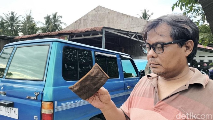 Pemilik kendaraan memperlihatkan komponen mobilnya yang rusak usai mengisi BBM di Padang.