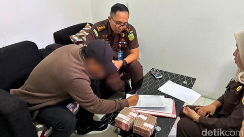 Salah seorang anggota DPRD NTB mengambil uang suap yang dikembalikan jaksa di Kejari Mataram, Senin (28/9/2026).