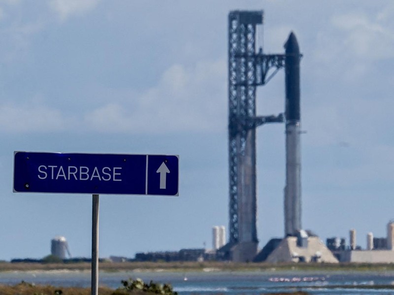 A Tesla Cybertruck drives past pad 2, where Starship 41 sits atop Super Heavy v3 Booster 21 at SpaceX launch complex, as preparations continue for the 14th test flight in Starbase, Texas, US, September 27, 2026. The mission is expected to send the vehicle into orbit for the first time and deploy 26 Starlink V3 satellites. REUTERS/Steve Nesius ,