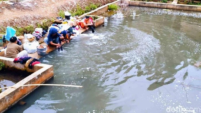 Warga Benteng mencuci pakaian di kolam ikan saat kemarau.