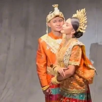 Asnawi dan Yuriska kompak dalam balutan busana adat yang didominasi warna oranye dihiasi motif dan ornamen berwarna emas. Penampilan keduanya makin lengkap dengan aksesori dan hiasan kepala yang juga berwarna emas. Foto: Instagram/@riomotret