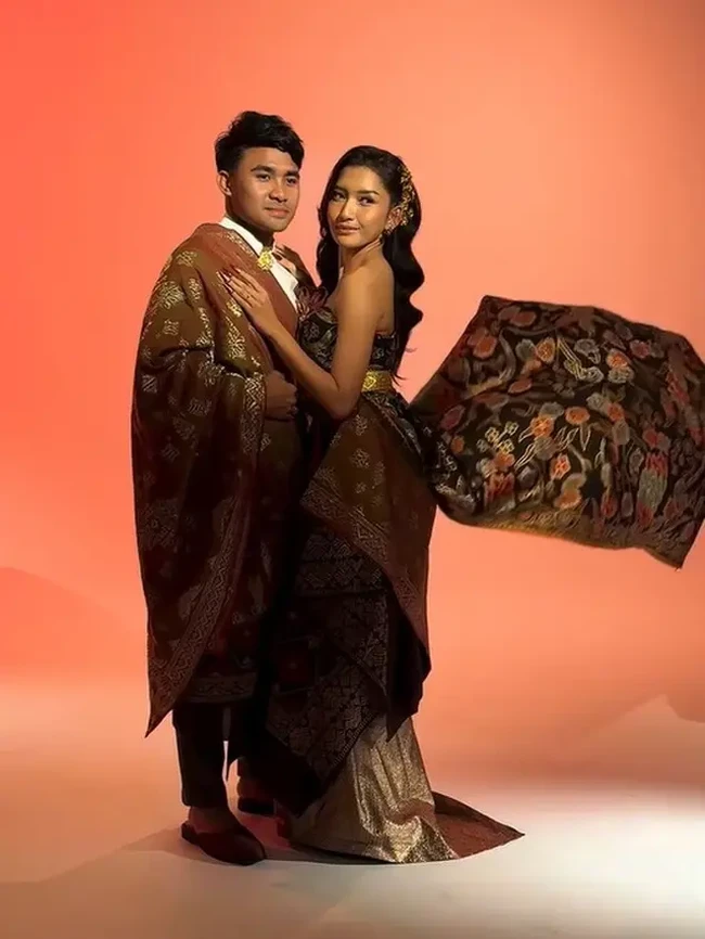 Pada tampilan kedua, Asnawi dan Yuriska tampil tak kalah memukau dalam balutan kain songket. Asnawi memadukan atasan lengan panjang putih polos dengan kain selempang songket. Foto: Instagram/@riomotret