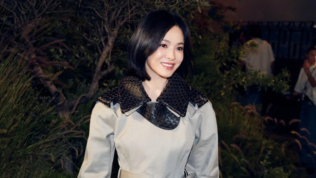 Gaya Song Hye Kyo dilengkapi dengan koleksi tas anyaman dan sepatu boots hitam keluaran rumah mode Italia tersebut. Foto: dok. Instagram @kyo1122