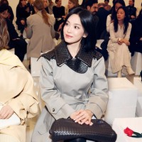 Bintang drama Korea The Glory itu menampilkan pesonanya, tampil dalam balutan trench coat abu-abu dengan kerah anyaman khas Bottega Veneta. Foto: dok. Instagram @kyo1122