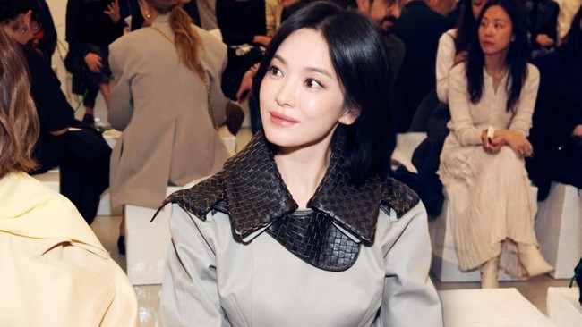 Bintang drama Korea The Glory itu menampilkan pesonanya, tampil dalam balutan trench coat abu-abu dengan kerah anyaman khas Bottega Veneta. Foto: dok. Instagram @kyo1122