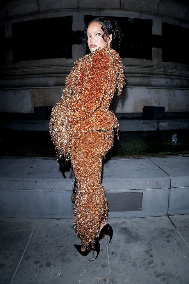Setelan jaket dan rok bernuansa bronze dengan detail seperti rumbai-rumbai metalik. Foto: WWD via Getty Images/WWD