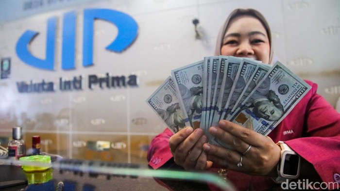 Petugas menghitung pecahan dolar AS dan rupiah di gerai penukaran mata uang asing VIP Money Changer, Jakarta, Selasa (29/9/2026).
