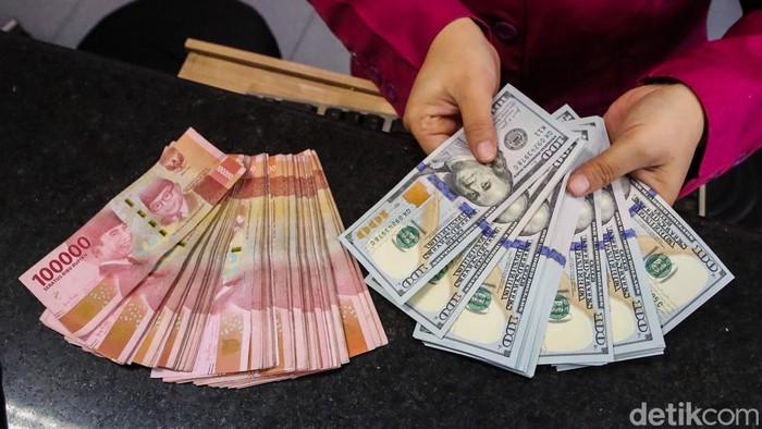 Petugas menghitung pecahan dolar AS dan rupiah di gerai penukaran mata uang asing VIP Money Changer, Jakarta, Selasa (29/9/2026).