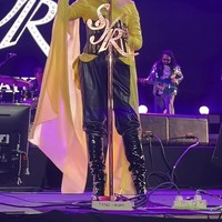 Syahrini diketahui mengenakan busana rancangan Ivan Gunawan. Ia mengenakan atasan berwarna kuning cerah dengan desain berkerah tinggi dan lengan panjang. Detail paling mencolok adalah kain kuning panjang menyerupa cape yang menjuntai dari sisi tubuh hingga menyentuh lantai. Foto: Instagram/@princessyahrini