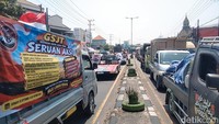Pantauan detikJatim di lokasi, ratusan truk yang melintas tampak membawa berbagai atribut aksi, mulai pengeras suara seperti sound horeg, keranda hingga spanduk.