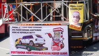 Spanduk berisi kritik terhadap kebijakan bahan bakar dan distribusi terpampang di salah satu kendaraan dalam aksi unjuk rasa sopir truk di Surabaya.