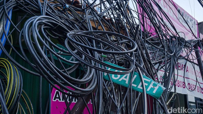 Tumpukan kabel udara yang semrawut dan menjuntai hingga ke trotoar di kawasan Jalan Raden Saleh, Ciledug, Kota Tangerang, kini mulai diamankan. Petugas memasang garis pengaman di sekitar area kabel pada Rabu (30/9/2026) untuk mencegah warga mendekati lokasi.