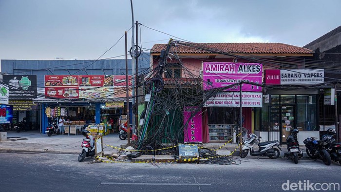 Tumpukan kabel udara yang semrawut dan menjuntai hingga ke trotoar di kawasan Jalan Raden Saleh, Ciledug, Kota Tangerang, kini mulai diamankan. Petugas memasang garis pengaman di sekitar area kabel pada Rabu (30/9/2026) untuk mencegah warga mendekati lokasi.