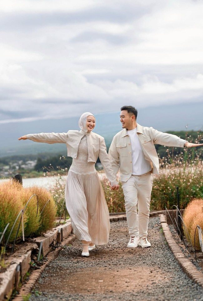 Puteri tampil dengan dress panjang dipadukan jaket crop top dan hijab senada. Sementara Ardi memadukan kaos putih dengan celana panjang dan kemeja warna beige yang dijadikan outer. Foto: Instagram/@putmod