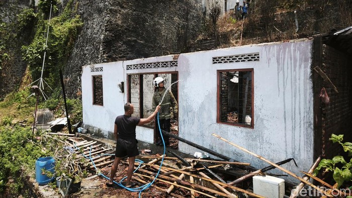 Petugas Damkar Kota Semarang saat melakukan pendinginan rumah terbakar di RT6/RW6 Kelurahan Lempongsari, Kecamatan Gajahmungkur, Rabu (30/9).