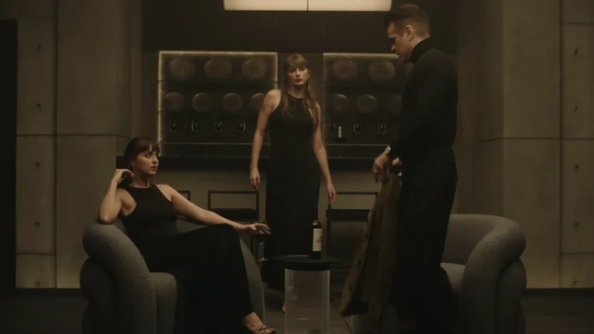Ketika karakter Colin Farrell mulai muncul dalam cerita, Taylor Swift dan Dakota Johnson masih tampil kembar. Kali ini keduanya mengenakan little black dress dari Saint Laurent.Keduanya juga melengkapi penampilan dengan sandal hitam bertali dari Saint Laurent. Foto: Dok. Instagram/YouTube Taylor Swift