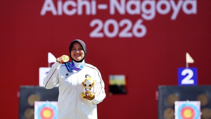 Asian Games - Aichi-Nagoya 2026 - Archery - Okazaki Central Park Multipurpose Square, Okazaki, Japan - October 1, 2026  Gold medallist Indonesias Nurisa Dian Ashrifah celebrates on the podium during the Compound Womens Individual Victory Ceremony REUTERS/Anushree Fadnavis