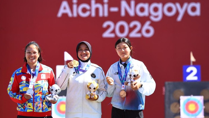 Asian Games - Aichi-Nagoya 2026 - Archery - Okazaki Central Park Multipurpose Square, Okazaki, Japan - October 1, 2026  Gold medallist Indonesias Nurisa Dian Ashrifah celebrates on the podium during the Compound Womens Individual Victory Ceremony with silver medallist Philippines Amaya Amparo Cojuangco and bronze medallist South Koreas Kang Yeonseo REUTERS/Anushree Fadnavis