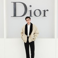 Hwang Hyunjin membawa nuansa tailoring maskulin ke front row Dior. Member Stray Kids tersebut mengenakan bomber jacket berwarna beige dari Dior Men Spring 2027. Jaket dengan kerah shawl hitam itu dipadukan dengan kemeja putih dan celana tailoring hitam. (Foto: Dok. Dior)