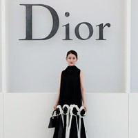 Aktris Jepang Mitsuki Takahata tampil dalam gaya klasik serba hitam. Ia mengenakan gaun panjang tanpa lengan berwarna hitam dengan tekstur pleats dan kerah tinggi. Bagian bawah gaun dihiasi detail bunga tiga dimensi berwarna hitam dan putih yang memberikan kontras pada keseluruhan tampilan. (Foto: Dok. Dior)