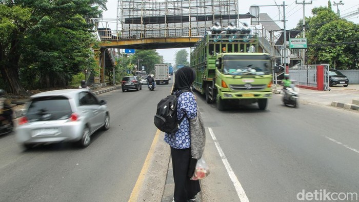 Sejumlah pelajar menunggu kendaraan saat akan menyeberang di kawasan Kranji, Bekasi, Kamis (1/10/2026). JPO yang biasa digunakan warga terlihat mengalami kerusakan.