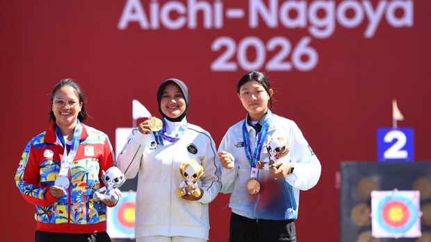 Pemain Indonesia Nurisa Dian Ashrifah merayakan keberhasilannya meraih medali emas di atas podium bersama peraih medali perak Amaya Amparo Cojuangco dari Filipina dan peraih medali perunggu Kang Yeonseo dari Korea Selatan dalam seremoni kemenangan nomor individu compound putri panahan Asian Games Aichi-Nagoya 2026, di Okazaki Central Park Multipurpose Square, Okazaki, Jepang, (1/10/2026). (REUTERS/Anushree Fadnavis)