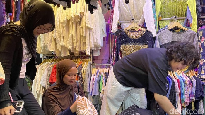 Tiga mahasiswi UIN Bandung tengah berbelanja pakaian thrift di Pasar Cimol Gedebage, Bandung, Kamis (1/10/2026).