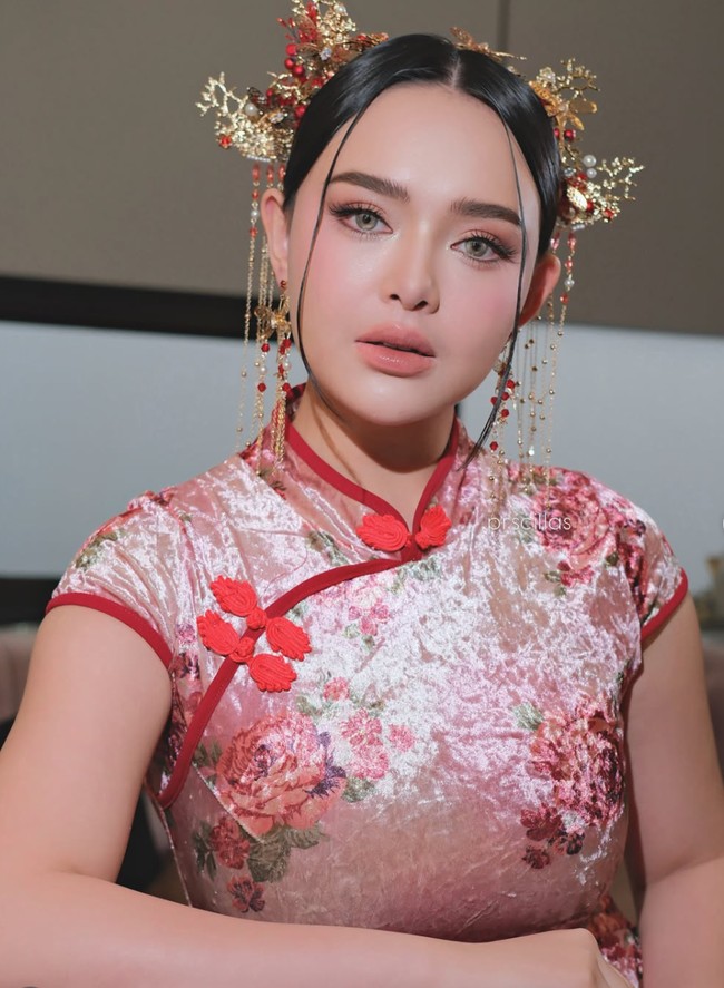 Di look kedua ibu satu orang anak itu kenakan cheongsam motif floral berwarna merah. Hair piece yang dikenakan juga tampak lebih ramai dibandingkan dengan look sebelumnya. Foto: Instagram/@prscillas