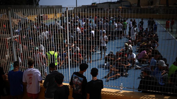 Migrants from Morocco gather at a sports field to be registered, following recent mass crossings of migrants from Morocco into Ceuta, in Ceuta, Spain, October 1, 2026. REUTERS/Pedro Nunes