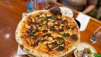 Rendang juga hadir dalam bentuk pizza thin crust. Pizza Rendang memadukan cita rasa Indonesia dan Barat. Selain itu masih banyak makanan lainnya di JimBARan Lounge. Foto: detikFood