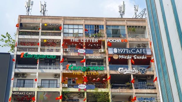 Apartemen tua di Ho Chi Minh City, Vietnam, yang dipenuhi kafe, toko, dan restoran di setiap balkon.