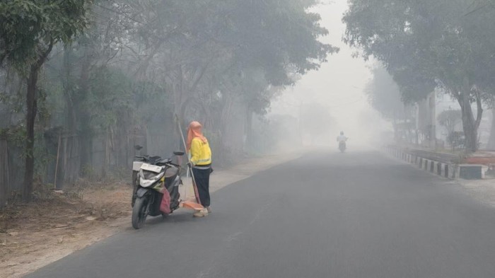 Petugas kebersihan menyapu jalan pada Sabtu (3/10/2026) pagi