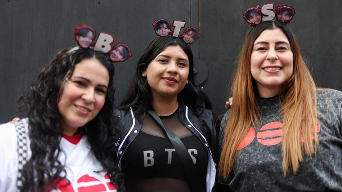 A BTS fan poses with merchandise after visiting the BTS POP-UP : ARIRANG, as other fans wait in line ahead of the South Korean Kpop group's two sold-out concerts at El Campin stadium on October 2 and 3, in Bogota, Colombia, October 1, 2026. REUTERS/Luisa Gonzalez