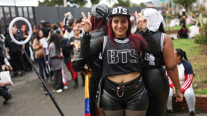 A BTS fan poses with merchandise after visiting the BTS POP-UP : ARIRANG, as other fans wait in line ahead of the South Korean Kpop group's two sold-out concerts at El Campin stadium on October 2 and 3, in Bogota, Colombia, October 1, 2026. REUTERS/Luisa Gonzalez