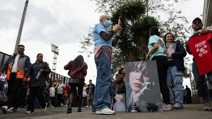 A BTS fan poses with merchandise after visiting the BTS POP-UP : ARIRANG, as other fans wait in line ahead of the South Korean Kpop group's two sold-out concerts at El Campin stadium on October 2 and 3, in Bogota, Colombia, October 1, 2026. REUTERS/Luisa Gonzalez