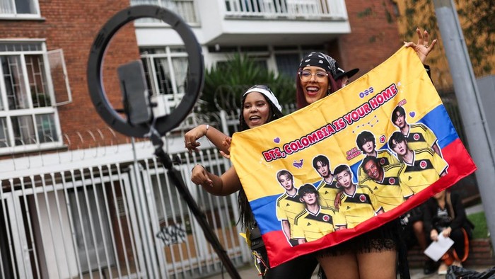 A BTS fan poses with merchandise after visiting the BTS POP-UP : ARIRANG, as other fans wait in line ahead of the South Korean Kpop group's two sold-out concerts at El Campin stadium on October 2 and 3, in Bogota, Colombia, October 1, 2026. REUTERS/Luisa Gonzalez