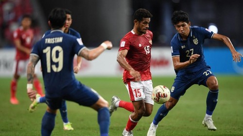 Indonesias Ricky Richardo Kambuaya (C) controls the ball past Thailands Tristan Do (L) and Weerathep Pomphun during the first leg of the AFF Suzuki Cup 2020 football final match between Indonesia and Thailand at the National Stadium in Singapore on December 29, 2021. (Photo by Roslan RAHMAN / AFP)