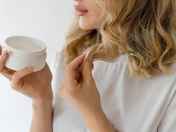 Ilustrasi wanita memakai leave-in conditioner.
