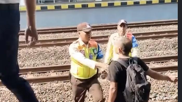 Tangkapan layar memperlihatkan seorang pria melawan saat nekat masuk ke jalur KA di Stasiun Maguwo, Sleman, Minggu (4/10/2026).