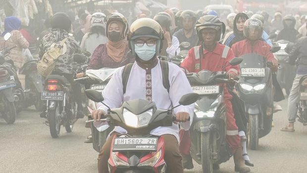 Warga melintasi jalan saat kabut asap akibat kebakaran hutan dan lahan menyelimuti Palembang, Sumatra Selatan, pada 2 Oktober 2026. Kebakaran hutan dan lahan di Indonesia sebagian besar disebabkan oleh praktik pembukaan lahan dengan cara membakar, yang mengakibatkan hilangnya tutupan hutan tahan api serta pengeringan lahan gambut. Warga melintasi jalan saat kabut asap akibat kebakaran hutan dan lahan menyelimuti Palembang, Sumatra Selatan, pada 2 Oktober 2026. Kebakaran hutan dan lahan di Indonesia sebagian besar disebabkan oleh praktik pembukaan lahan dengan cara membakar, yang mengakibatkan hilangnya tutupan hutan tahan api serta pengeringan lahan gambut. (AL ZULKIFLI / AFP)