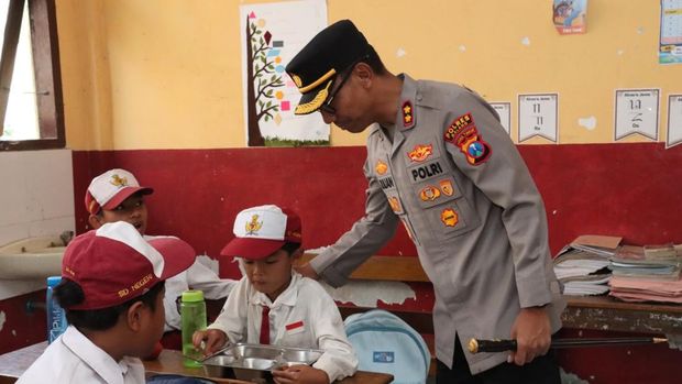 Kapolres Malang AKBP Rulian Syauri bersama Ketua Yayasan Kemala Bhayangkari Cabang Malang, Desy Rulian Syauri, meninjau uji coba program MBG sistem prasmanan. (dok Istimewa)