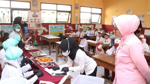 Kapolres Malang AKBP Rulian Syauri bersama Ketua Yayasan Kemala Bhayangkari Cabang Malang, Desy Rulian Syauri, meninjau uji coba program MBG sistem prasmanan. (dok Istimewa)