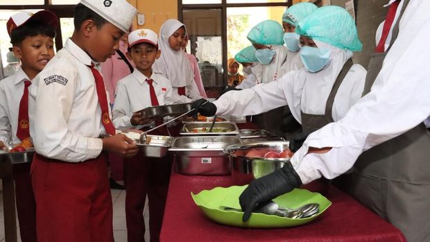 Kapolres Malang AKBP Rulian Syauri bersama Ketua Yayasan Kemala Bhayangkari Cabang Malang, Desy Rulian Syauri, meninjau uji coba program MBG sistem prasmanan. (dok Istimewa)