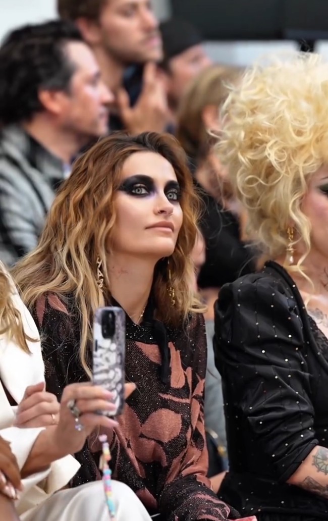 Paris mengenakan riasan smoky eyes hitam yang dibuat sangat tebal. Pigmen hitam mengelilingi hampir seluruh area matanya, dari garis bulu mata hingga mendekati alis dan pelipis. Gaya ini populer disebut raccoon makeup, istilah untuk teknik riasan mata hitam yang diaplikasikan dengan efek messy dan melingkari area mata. Foto: Tangkapan layar Instagram/@parisjackson Paris mengenakan riasan smoky eyes hitam yang dibuat sangat tebal. Pigmen hitam mengelilingi hampir seluruh area matanya, dari garis bulu mata hingga mendekati alis dan pelipis. Gaya ini populer disebut raccoon makeup, istilah untuk teknik riasan mata hitam yang diaplikasikan dengan efek messy dan melingkari area mata. Foto: Tangkapan layar Instagram/@parisjackson