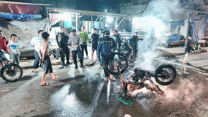Satu unit sepeda motor jenis trail dibakar massa saat tawuran di Makassar.