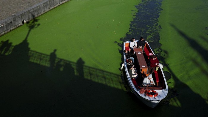 A sightseeing boat travels along a duckweed-covered section of the River Lys in Ghent, Belgium, October 5, 2026. Prolonged hot and dry weather led to a surge in duckweed growth on the river following one of Europe's driest summers on record. REUTERS/Stephanie Lecocq