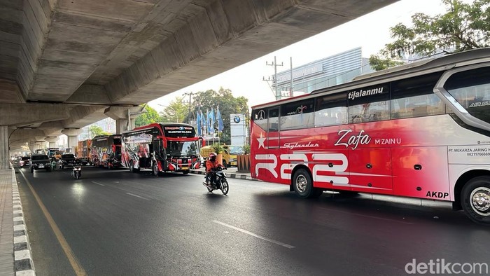 Truk dan bus parkir di Jalan AP Pettarani Makassar menunggu antrean isi solar di SPBU.